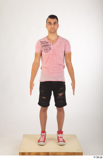Colin black shorts clothing pink t shirt red shoes standing…